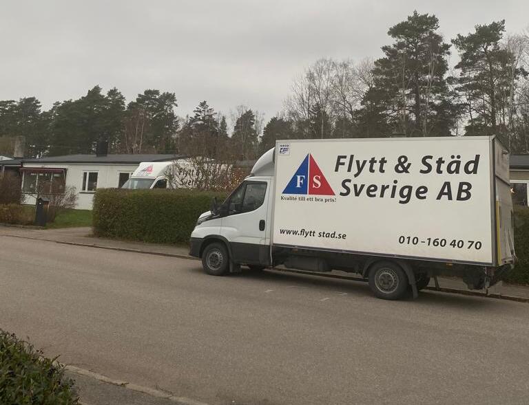 Två flyttbilar med personal utanför bostad